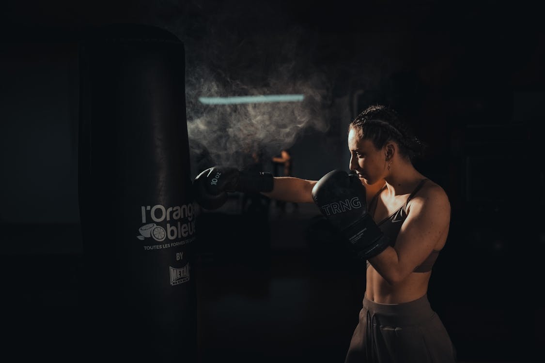 ジムで集中してパンチの練習をする女性ボクサー